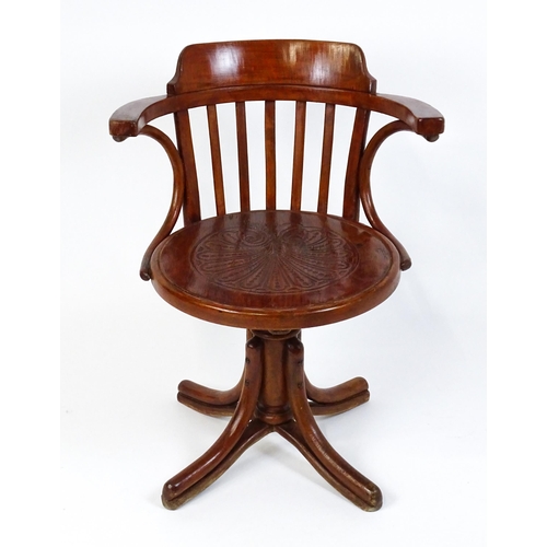 1516 - An early 20thC Thonet desk chair / revolving chair with a slatted backrest and embossed seat above a... 