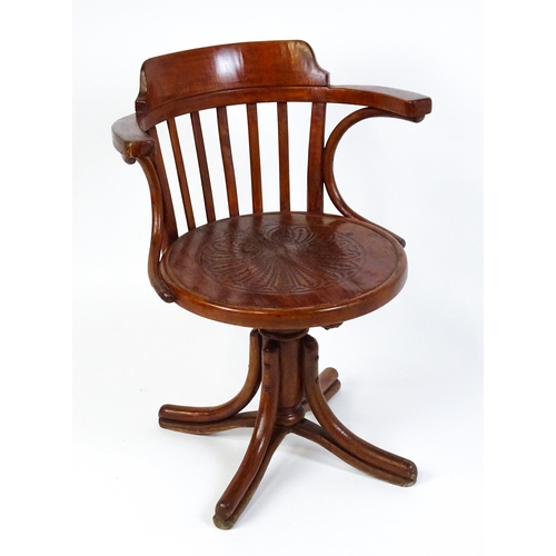 1516 - An early 20thC Thonet desk chair / revolving chair with a slatted backrest and embossed seat above a... 