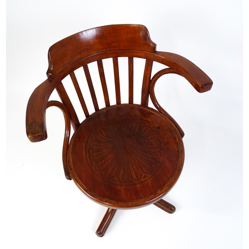 1516 - An early 20thC Thonet desk chair / revolving chair with a slatted backrest and embossed seat above a... 