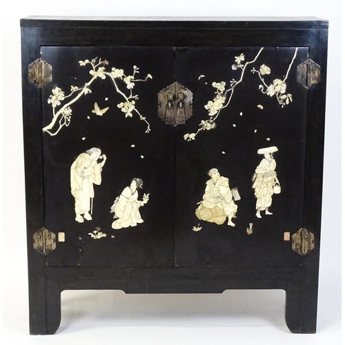 1520 - A late 19thC / early 20thC oriental cabinet with figural decoration to the doors. 48