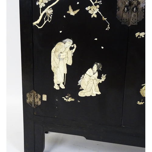 1520 - A late 19thC / early 20thC oriental cabinet with figural decoration to the doors. 48