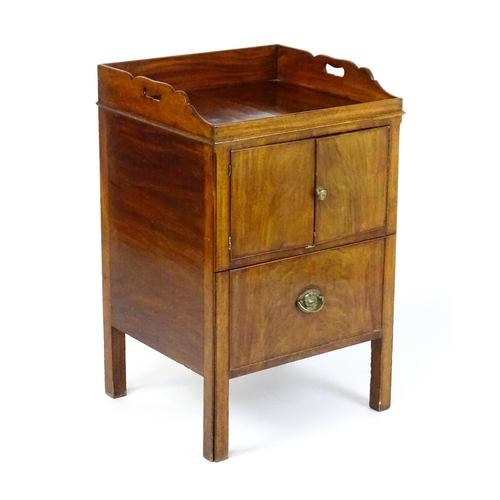 1522 - A Georgian mahogany tray top commode / bedside cabinet with pierced handles above two panelled doors... 