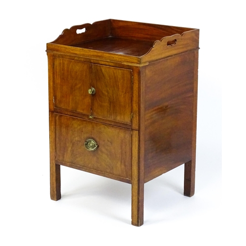 1522 - A Georgian mahogany tray top commode / bedside cabinet with pierced handles above two panelled doors... 