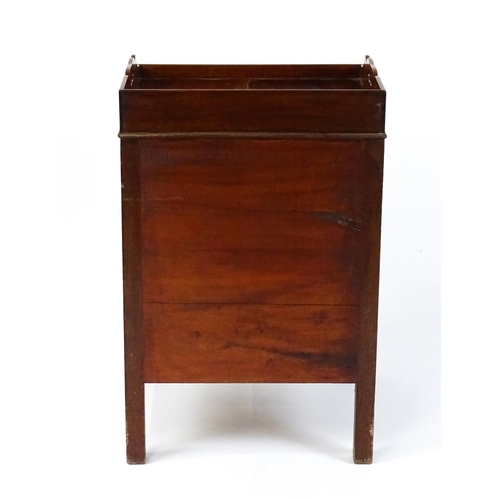 1522 - A Georgian mahogany tray top commode / bedside cabinet with pierced handles above two panelled doors... 