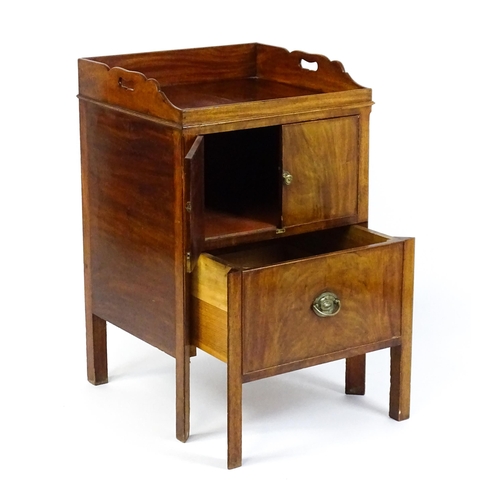 1522 - A Georgian mahogany tray top commode / bedside cabinet with pierced handles above two panelled doors... 