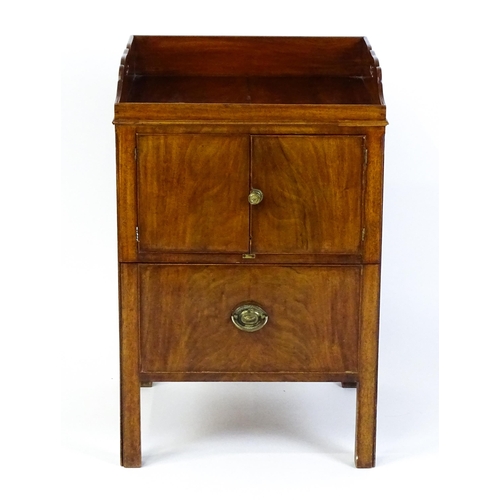 1522 - A Georgian mahogany tray top commode / bedside cabinet with pierced handles above two panelled doors... 