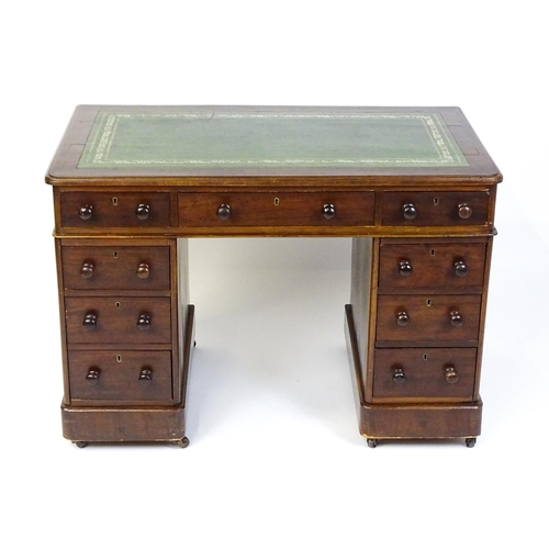 1525 - A late 19thC / early 20thC mahogany double pedestal desk with a green tooled leather top above two b... 