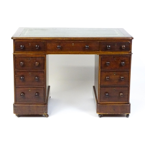 1525 - A late 19thC / early 20thC mahogany double pedestal desk with a green tooled leather top above two b... 