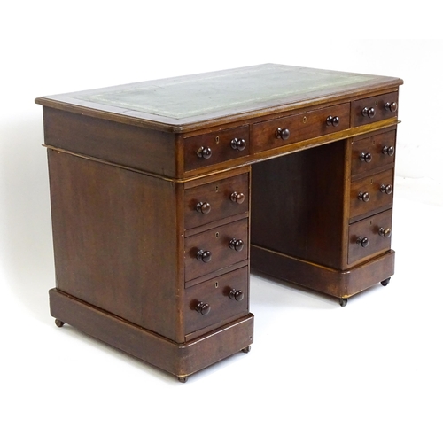 1525 - A late 19thC / early 20thC mahogany double pedestal desk with a green tooled leather top above two b... 