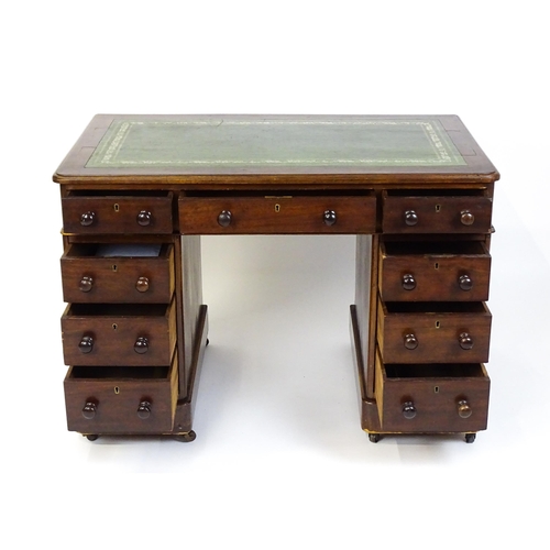 1525 - A late 19thC / early 20thC mahogany double pedestal desk with a green tooled leather top above two b... 