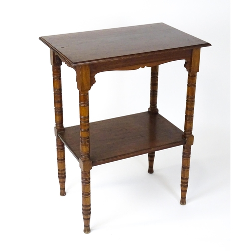 1534 - An Aesthetic movement mahogany two tier whatnot / etagere with a moulded top above four ring turned ... 