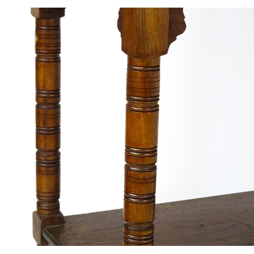 1534 - An Aesthetic movement mahogany two tier whatnot / etagere with a moulded top above four ring turned ... 