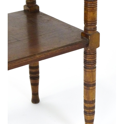 1534 - An Aesthetic movement mahogany two tier whatnot / etagere with a moulded top above four ring turned ... 