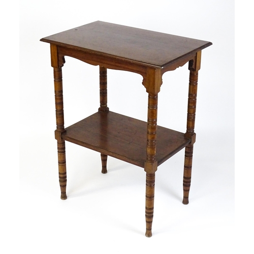 1534 - An Aesthetic movement mahogany two tier whatnot / etagere with a moulded top above four ring turned ... 