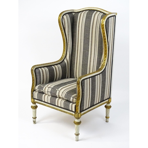 1557 - A Louis XVI style wingback armchair with a white and gold painted frame, striped upholstery and rais... 