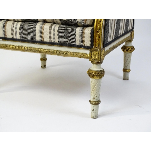 1557 - A Louis XVI style wingback armchair with a white and gold painted frame, striped upholstery and rais... 