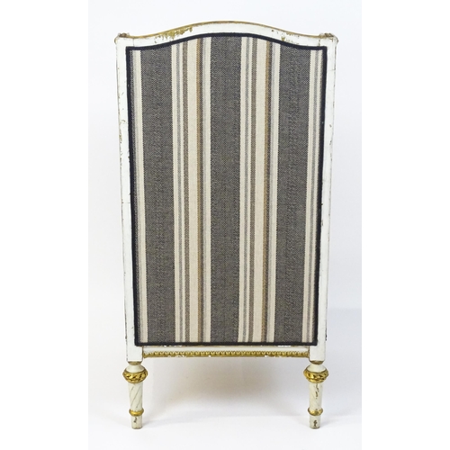 1557 - A Louis XVI style wingback armchair with a white and gold painted frame, striped upholstery and rais... 