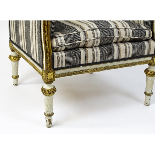 1557 - A Louis XVI style wingback armchair with a white and gold painted frame, striped upholstery and rais... 