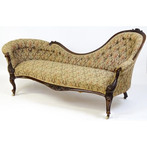 1572 - A Victorian sofa / chaise longue with a carved show wood frame and a deep buttoned backrest and spru... 