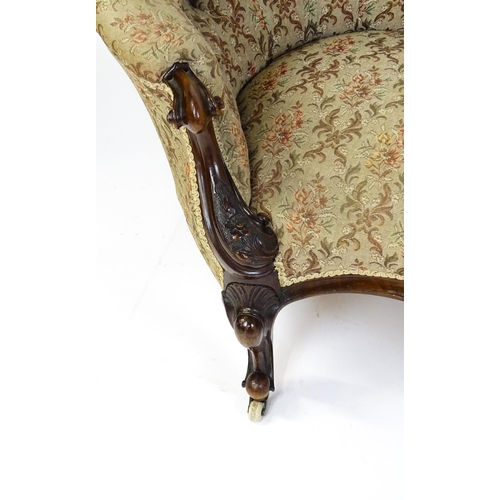 1572 - A Victorian sofa / chaise longue with a carved show wood frame and a deep buttoned backrest and spru... 