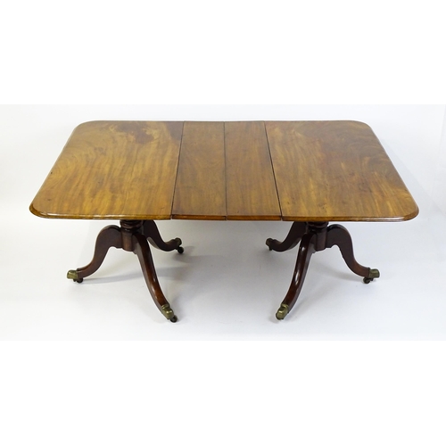 1603 - A 19thC mahogany double pedestal dining table with three additional leaves. The pedestals having tur... 