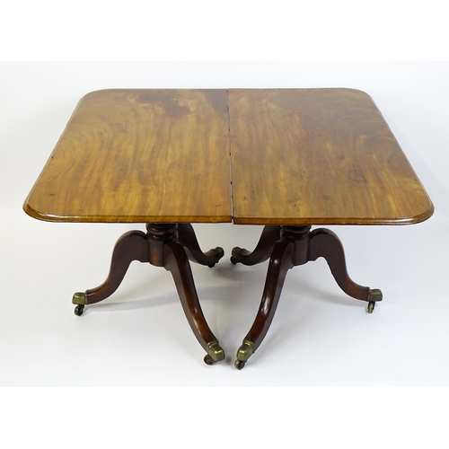 1603 - A 19thC mahogany double pedestal dining table with three additional leaves. The pedestals having tur... 