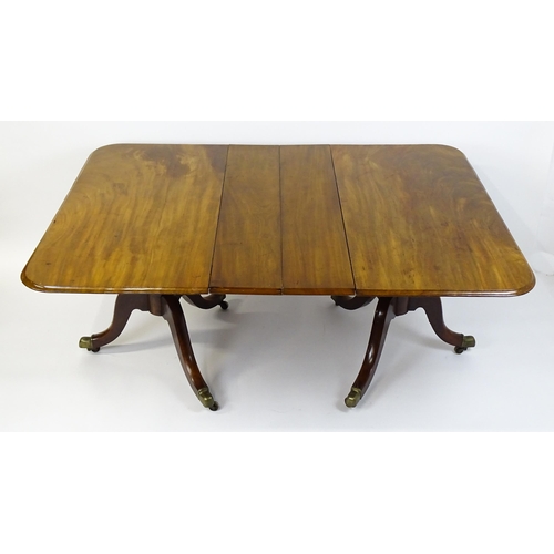 1603 - A 19thC mahogany double pedestal dining table with three additional leaves. The pedestals having tur... 