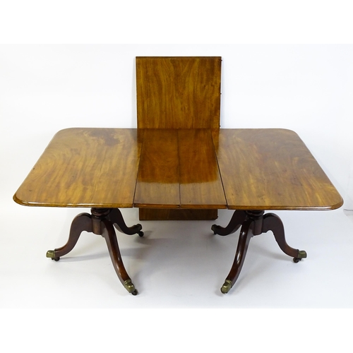 1603 - A 19thC mahogany double pedestal dining table with three additional leaves. The pedestals having tur... 