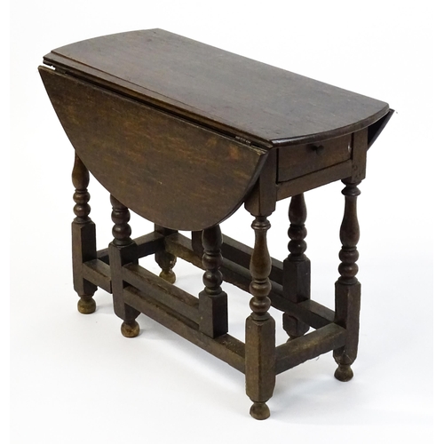 1625 - A 19thC oak gateleg table with two demi lune leaves and a single short drawer raised on block and tu... 