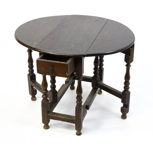 1625 - A 19thC oak gateleg table with two demi lune leaves and a single short drawer raised on block and tu... 