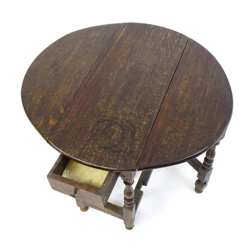 1625 - A 19thC oak gateleg table with two demi lune leaves and a single short drawer raised on block and tu... 