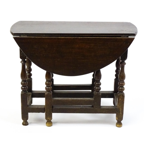 1625 - A 19thC oak gateleg table with two demi lune leaves and a single short drawer raised on block and tu... 