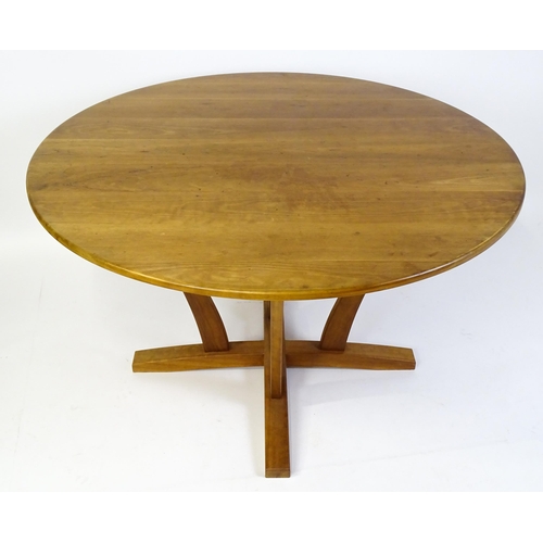 1634 - Vintage / Retro: A teak dining table with a circular top raised on four shaped supports with an x-fr... 