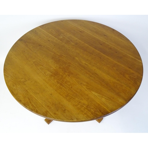 1634 - Vintage / Retro: A teak dining table with a circular top raised on four shaped supports with an x-fr... 