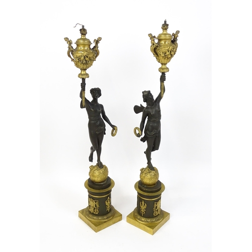 1234 - A large pair of 19thC cast bronze sculptural lamps, each modelled as a Classical female figure holdi... 