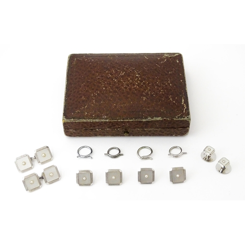 781 - A cased set of 9ct white gold studs and cufflinks with engine turned decoration and seed pearl detai... 