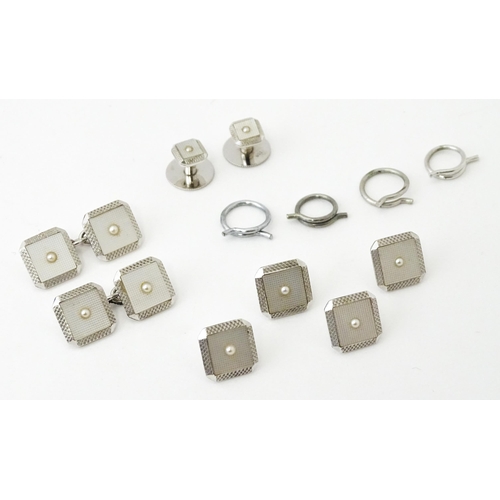 781 - A cased set of 9ct white gold studs and cufflinks with engine turned decoration and seed pearl detai... 