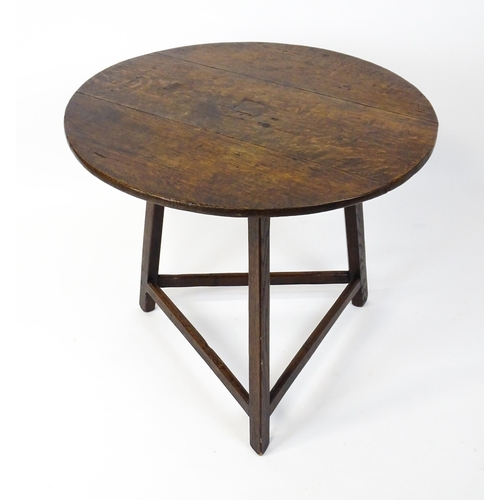 1441 - A 19thC oak cricket table with a circular top above three straight legs united by three stretchers f... 