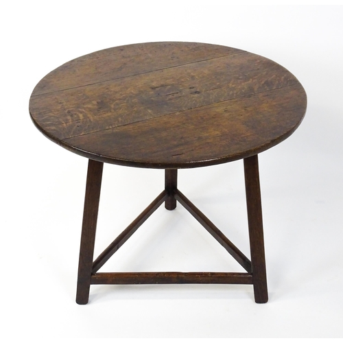 1441 - A 19thC oak cricket table with a circular top above three straight legs united by three stretchers f... 