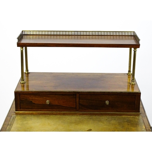 1448 - An early / mid 19thC rosewood Bonheur du jour with a brass gallery raised on four brass pillars, the... 