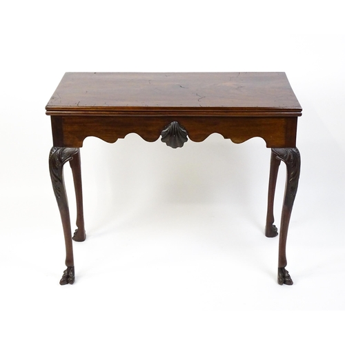 1450 - A late 18th / early 19thC Irish card table of mahogany construction. The table having a hinged top a... 