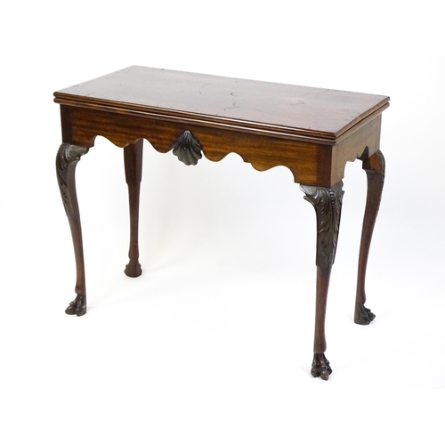 1450 - A late 18th / early 19thC Irish card table of mahogany construction. The table having a hinged top a... 