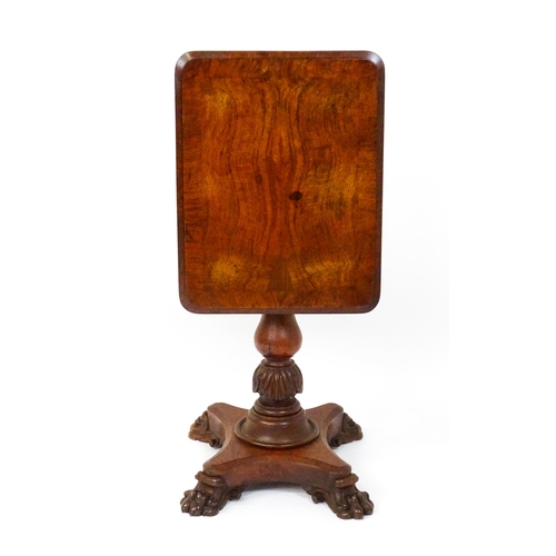 1465 - A 19thC oak tilt top table with a crossbanded top above a turned pedestal with carved acanthus decor... 