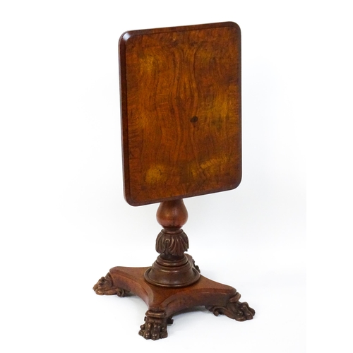 1465 - A 19thC oak tilt top table with a crossbanded top above a turned pedestal with carved acanthus decor... 