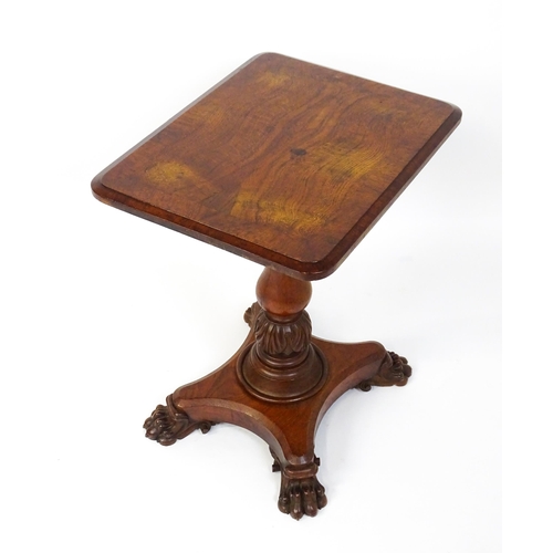 1465 - A 19thC oak tilt top table with a crossbanded top above a turned pedestal with carved acanthus decor... 