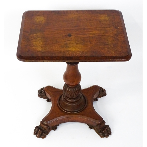 1465 - A 19thC oak tilt top table with a crossbanded top above a turned pedestal with carved acanthus decor... 