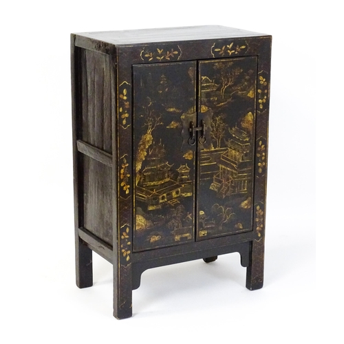 1469 - A late 19thC / early 20thC oriental cabinet with painted decoration depicting a village scene with p... 