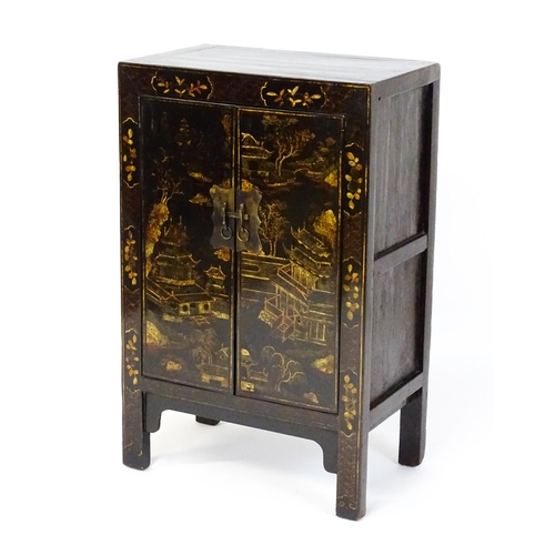 1469 - A late 19thC / early 20thC oriental cabinet with painted decoration depicting a village scene with p... 