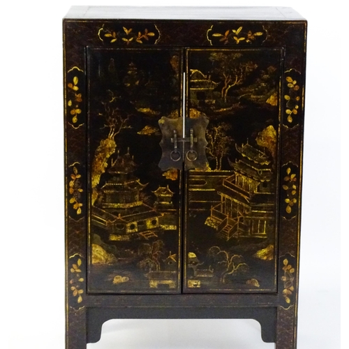 1469 - A late 19thC / early 20thC oriental cabinet with painted decoration depicting a village scene with p... 