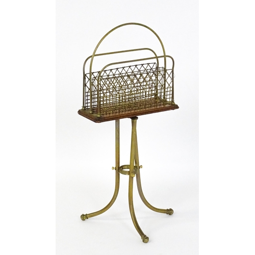 1508 - A mid 20thC Canterbury with a hoop handle above three grilled dividers raised on three brass legs. 3... 